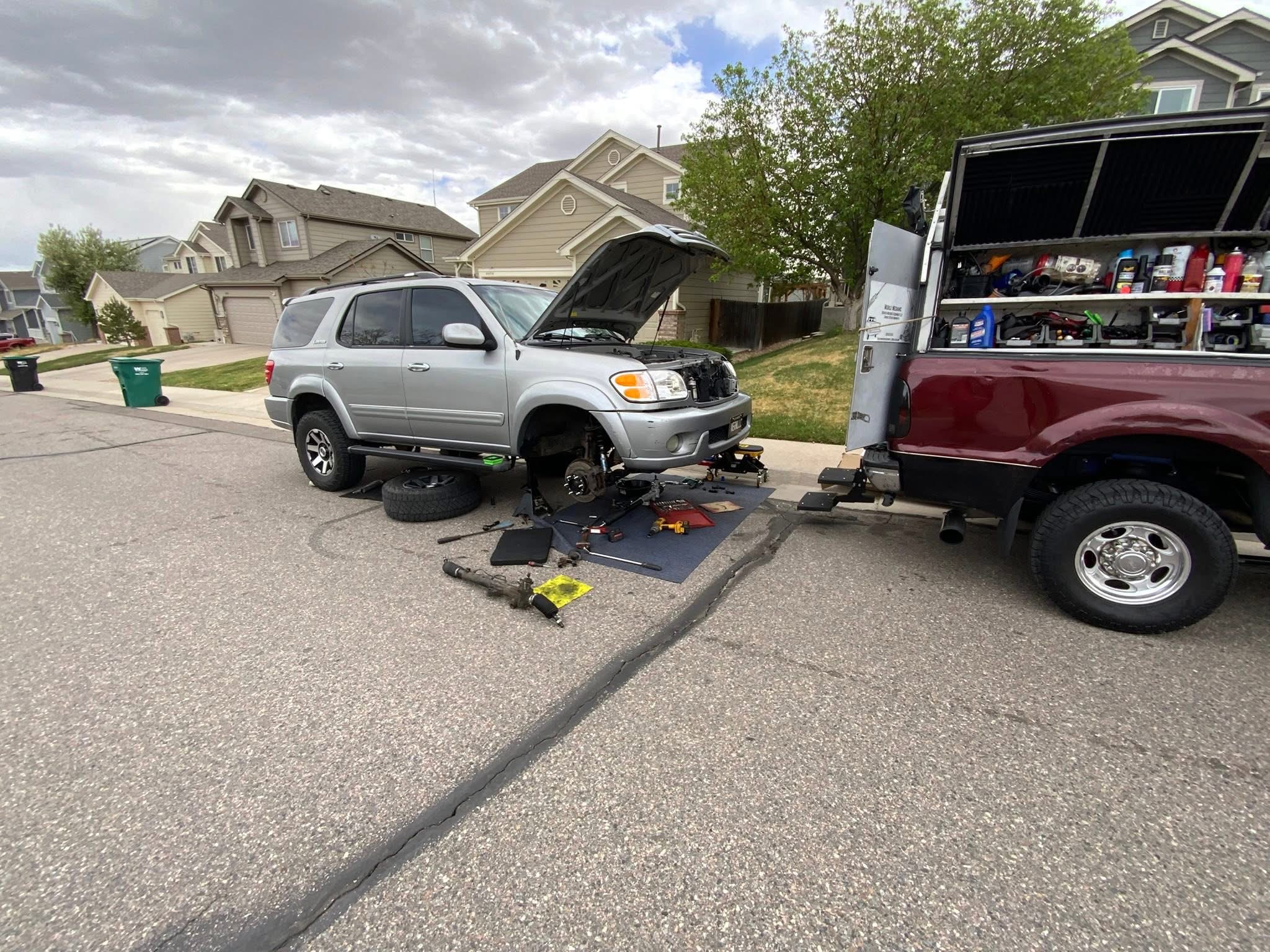 Mobile service setup with SUV and red work truck