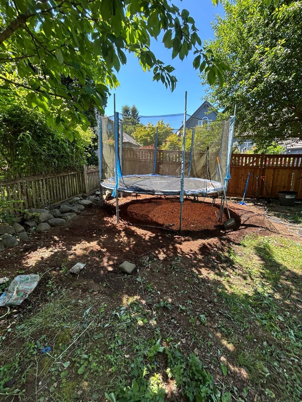 Cleared yard area around a trampoline after cleanup work